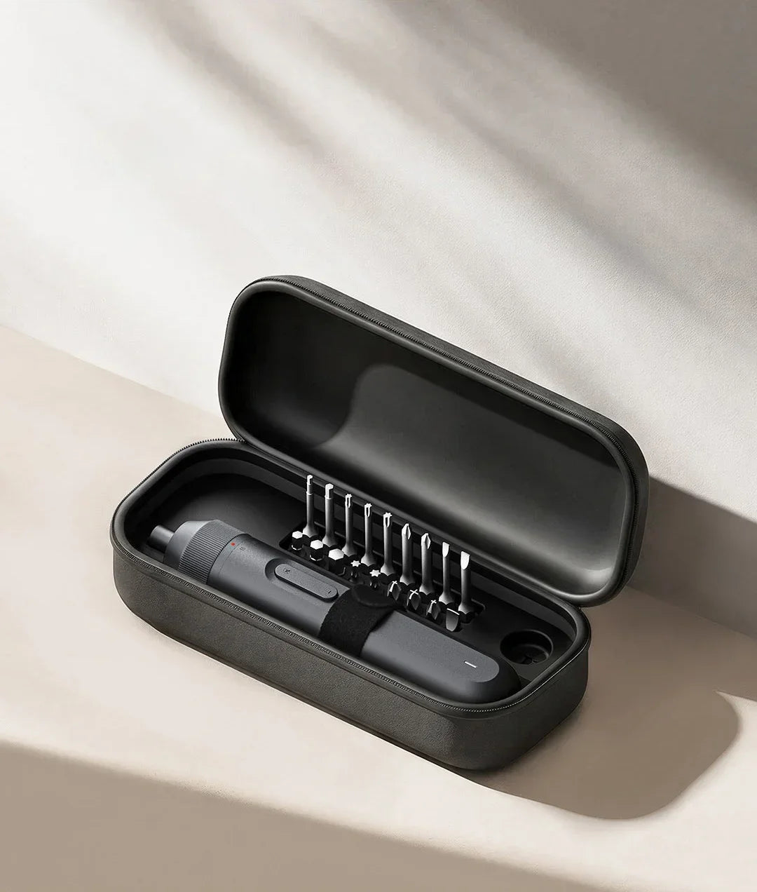 A black electric screwdriver in its open case showing multiple screwdriver bits.