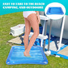 A person stands on a blue inflatable foot soaking basin outdoors near a camping setup.