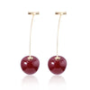A gold-toned pendant necklace featuring a deep red, polished stone.