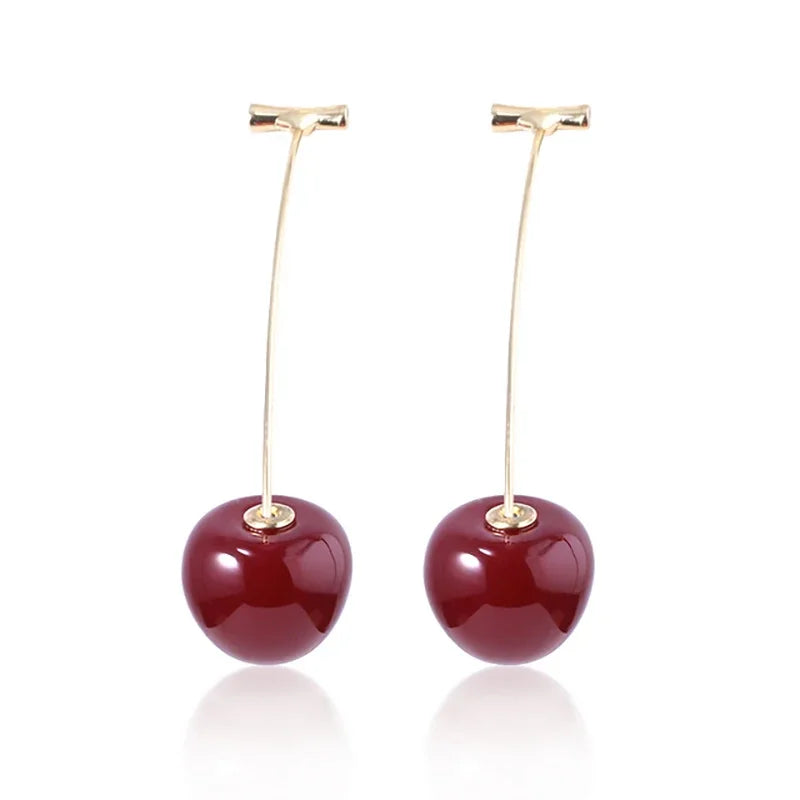 A gold-toned pendant necklace featuring a deep red, polished stone.