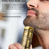 A close-up of a gold-colored electric razor with a Buddha design is being held by a man's hand.