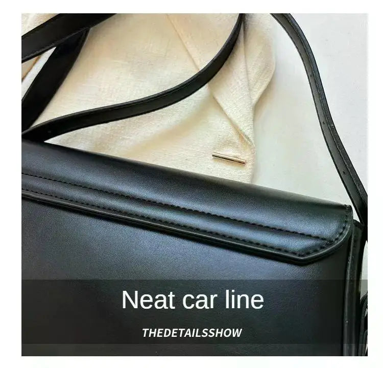 Black leather crossbody bag showing the neat car line detail on the flap and strap.