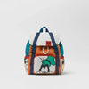 An orange and white cow print nylon backpack with blue trim and a black face design.