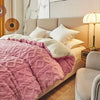 A pink quilted duvet cover and blanket is displayed on a light beige bed in a modern bedroom setting.