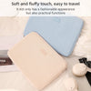 Una funda protectora rosa claro para portátil, apoyada sobre ropa de cama blanca.