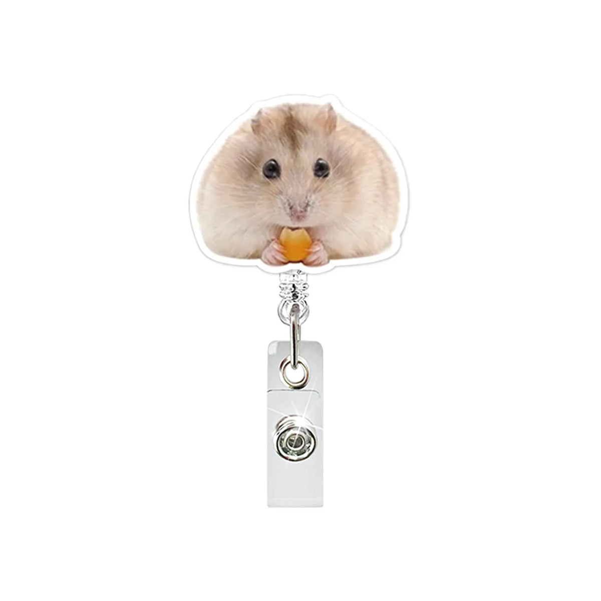 A fluffy light brown hamster is holding a piece of orange food while interacting with a retractable badge reel.