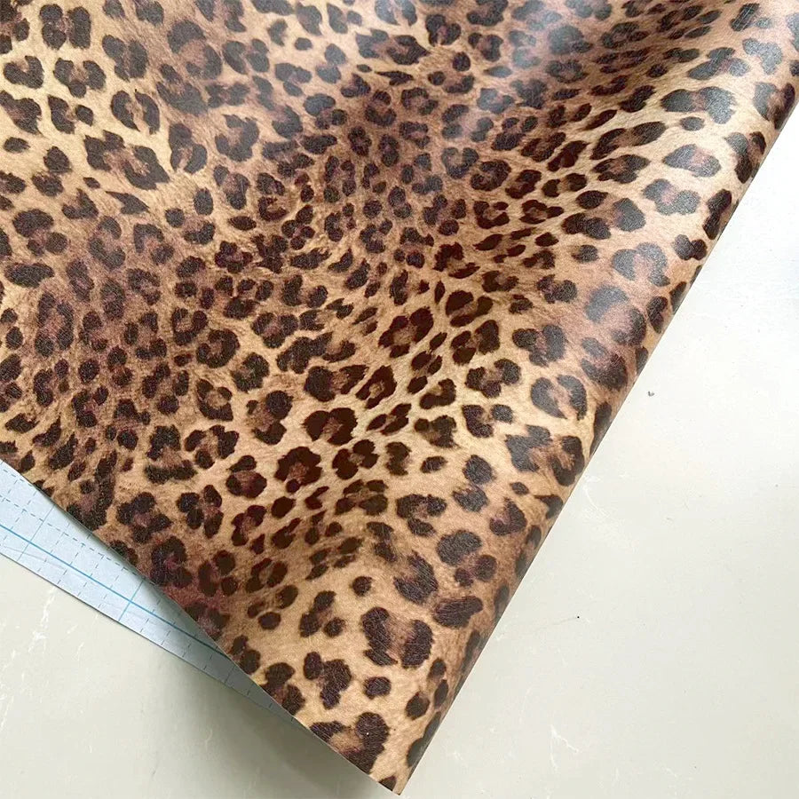 A close-up view of leopard print self-adhesive wallpaper sheet with a grid ruler visible.