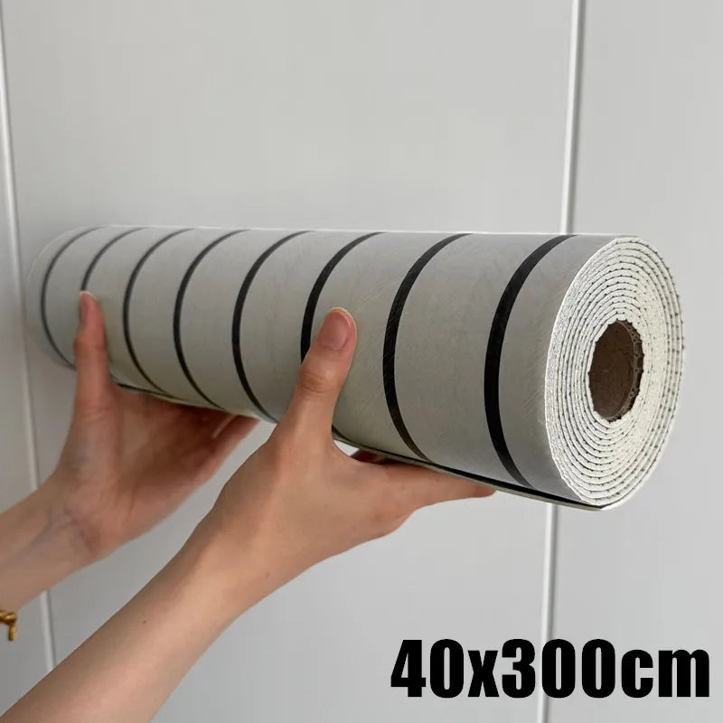 A hand is holding a roll of self-adhesive wood grain wall panels for accent walls and ceilings.