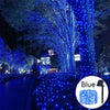 Blue fairy string lights illuminating a path and trees at night