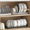 A wooden shelf displaying a silver and white expandable pot and pan organizer rack with adjustable dividers.