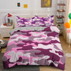 A purple and pink camouflage duvet cover set displayed on a bed with white nightstands and wooden shelving.