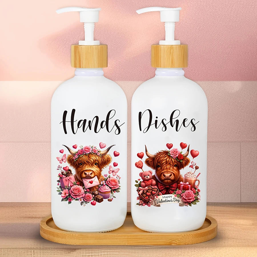 A pair of white soap dispensers with wooden caps and a tray, featuring illustrations of Highland cows for Valentine's Day.