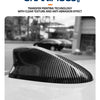Close-up of a black carbon streak antenna cover placed on a white car surface.