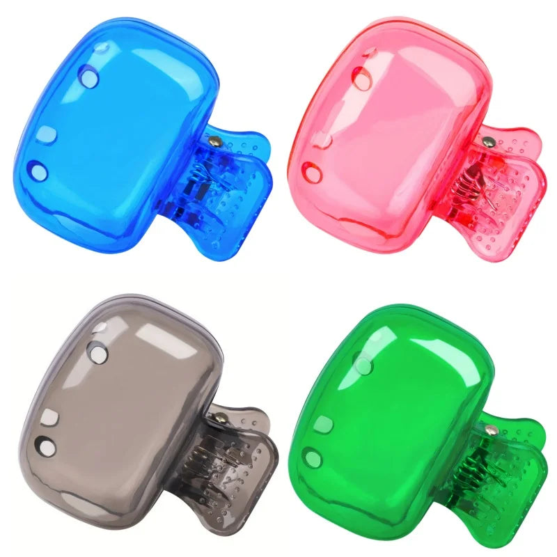 Three silicone toothbrush head covers in blue, pink, and green with clips shown from the side.