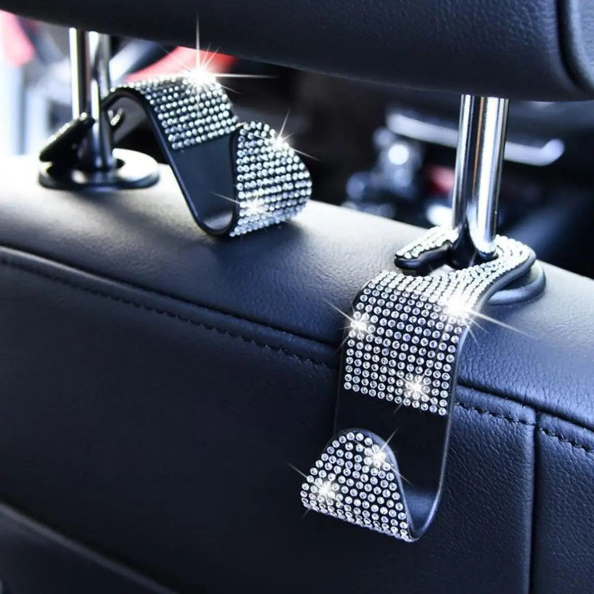 A set of black car seat storage hooks featuring crystal diamond accents.