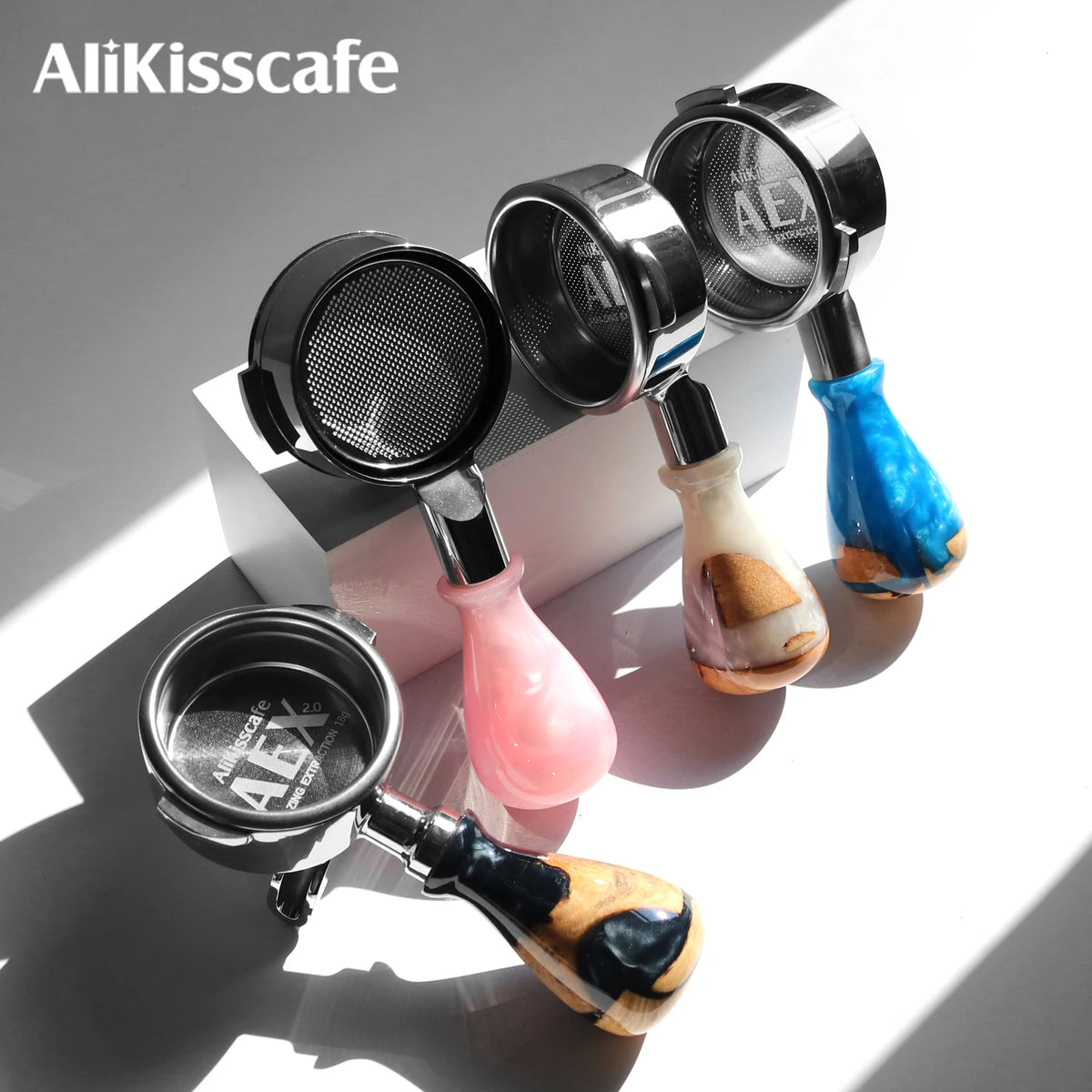 A collection of stainless steel bottomless espresso portafilters for various machines.