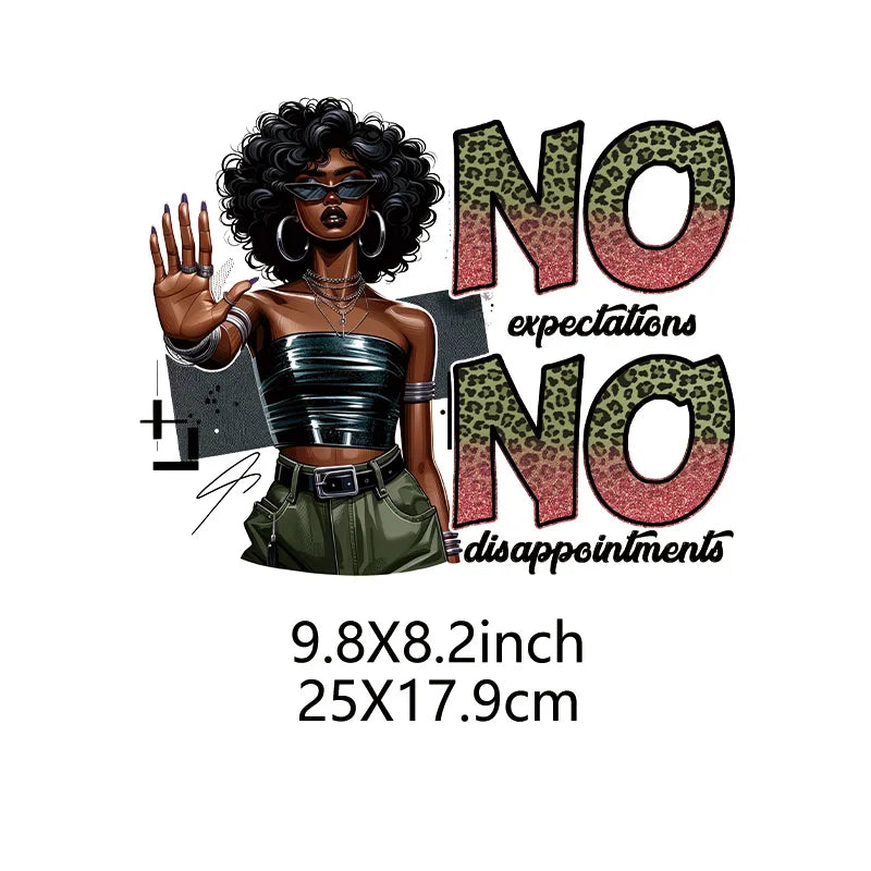 A woman with curly hair wearing sunglasses and a black top holds up text that reads NO expectations NO disappointments