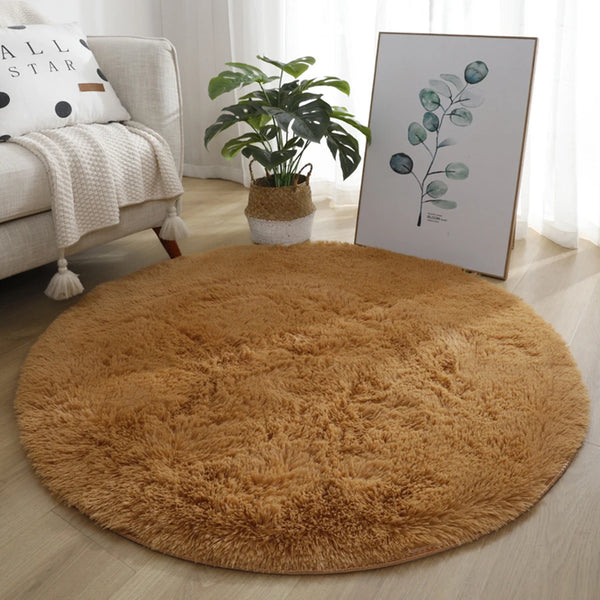 A round, golden brown ultra-plush shag area rug placed on a light wood floor.