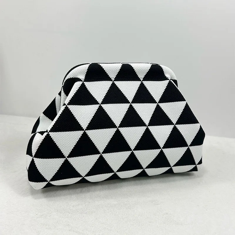 Clutch de diseño geométrico en blanco y negro con forma plegada.