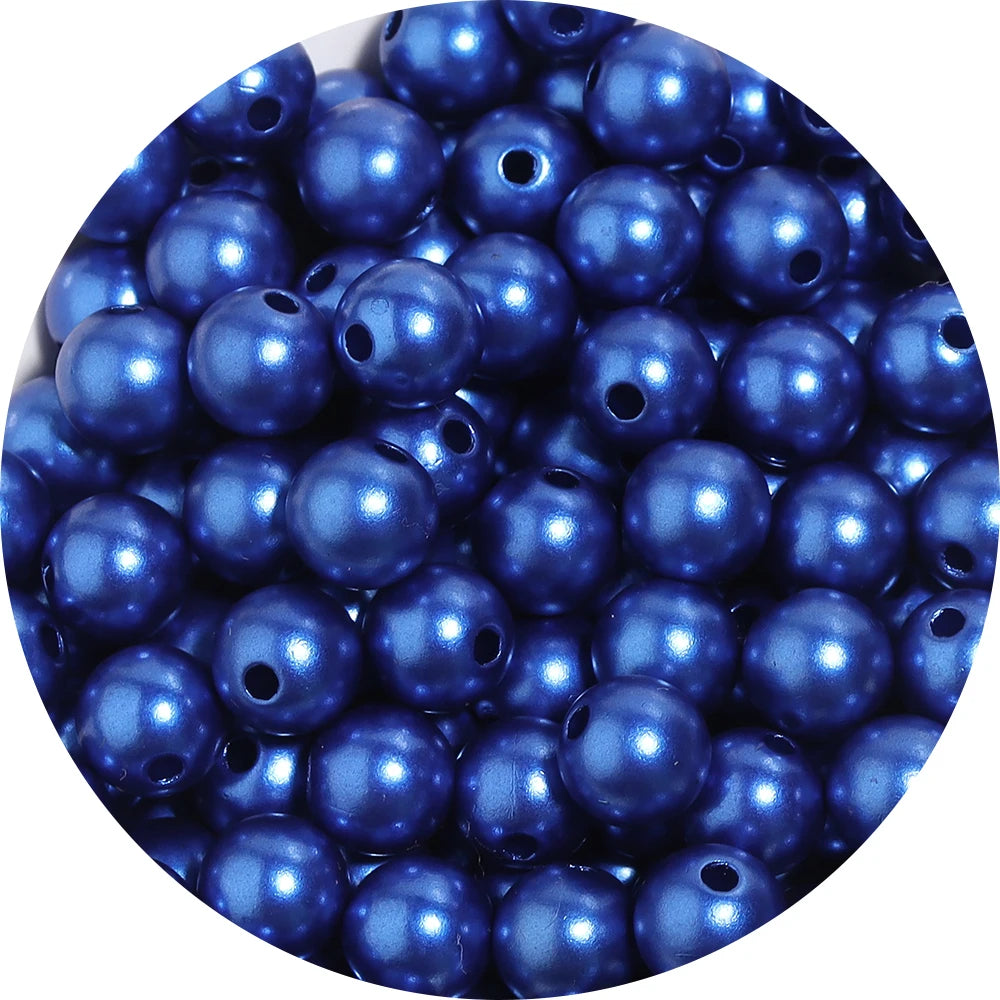 A close-up view of small, round, blue imitation pearl beads for jewelry making.