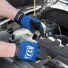 A hand wearing a blue performance tool glove is using a coin-type spark plug gap gauge on an engine component.
