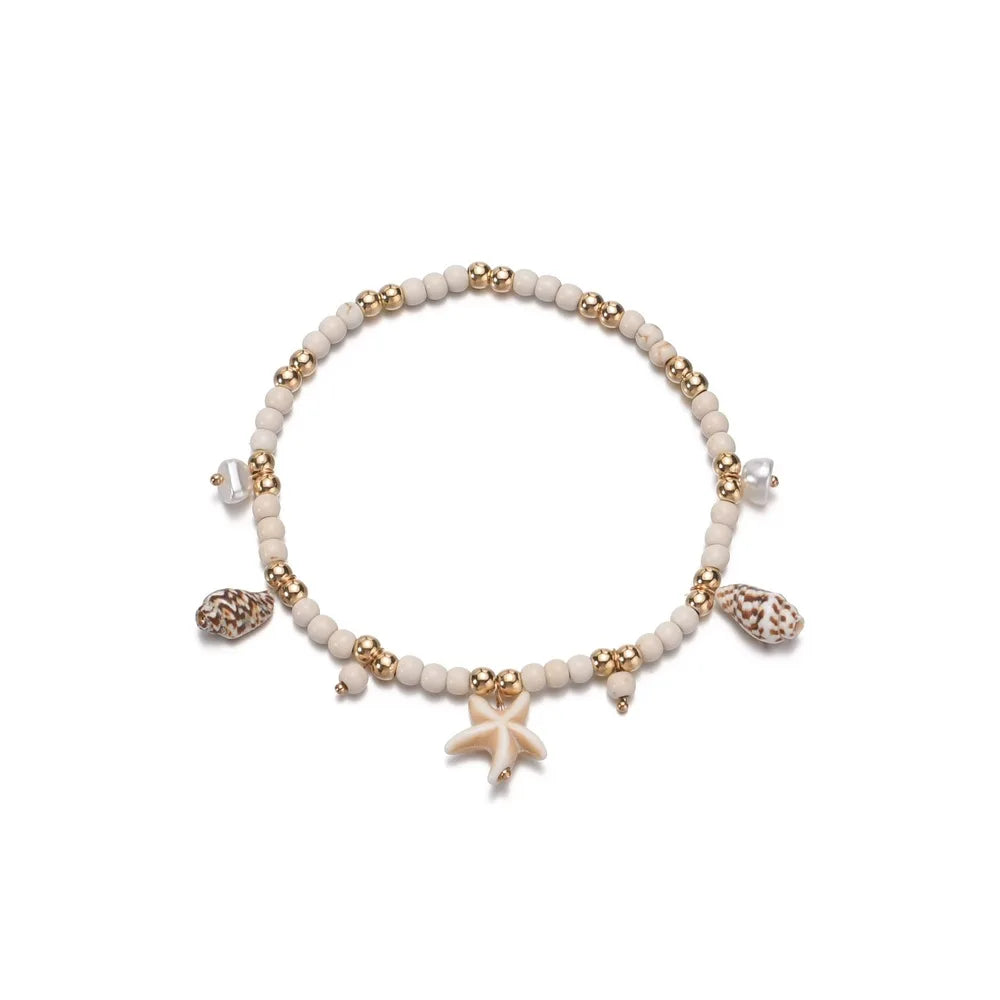 A vintage layered stone anklet featuring small beads and a geometric pendant.