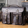 Dunkelbraunes Vintage-Ledertasche mit Messing-Hardware auf Holzoberfläche.