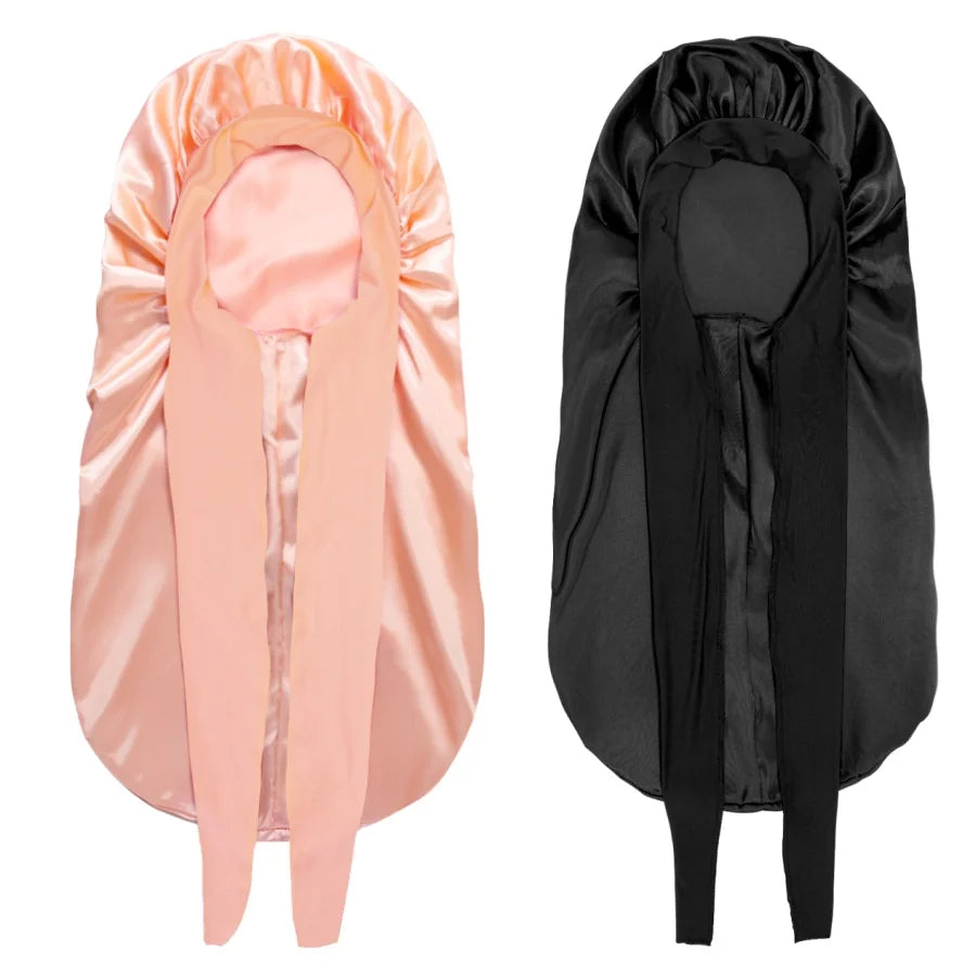 Ein Paar satinierte Schlafbonnets in pink und schwarz für lockiges Haar