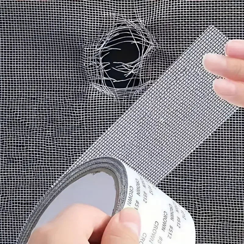 Eine Hand appliziert oder inspiziert Reparaturklebe für ein Moskitonetz auf ein Maschendrahtfenster.