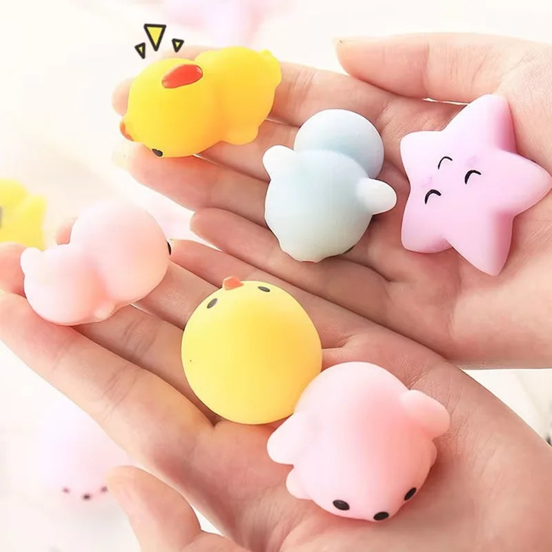 A hand holds several soft, squishy animal-shaped stress relief toys in yellow, pink, and blue colors.