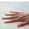 A hand is gently touching a white, fluffy textile product, likely the Encrypted Thickened Lamb Velvet.
