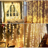 Close-up of warm yellow fairy string lights draped across a window and fabric, illuminating a room.