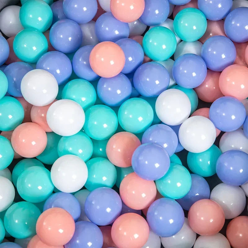A large collection of colorful plastic ball pit balls in shades of blue, pink, and white.