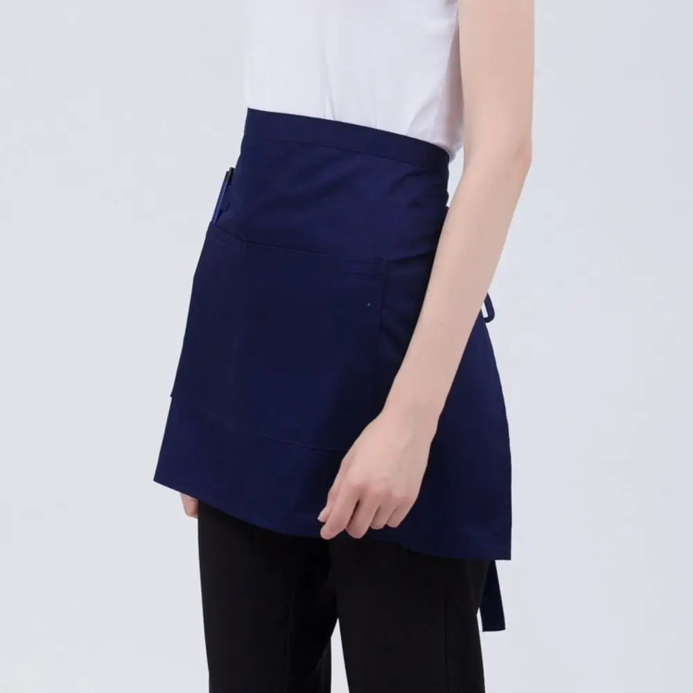 A navy blue classic half apron with pockets shown on a person's torso.