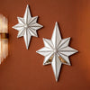 Two silver octagonal star resin wall mirrors mounted on a brown wall.