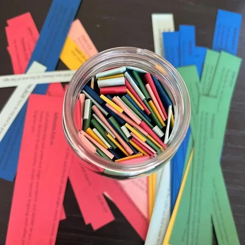 Un pot transparent rempli de cartes et de papiers avec des versets bibliques colorés