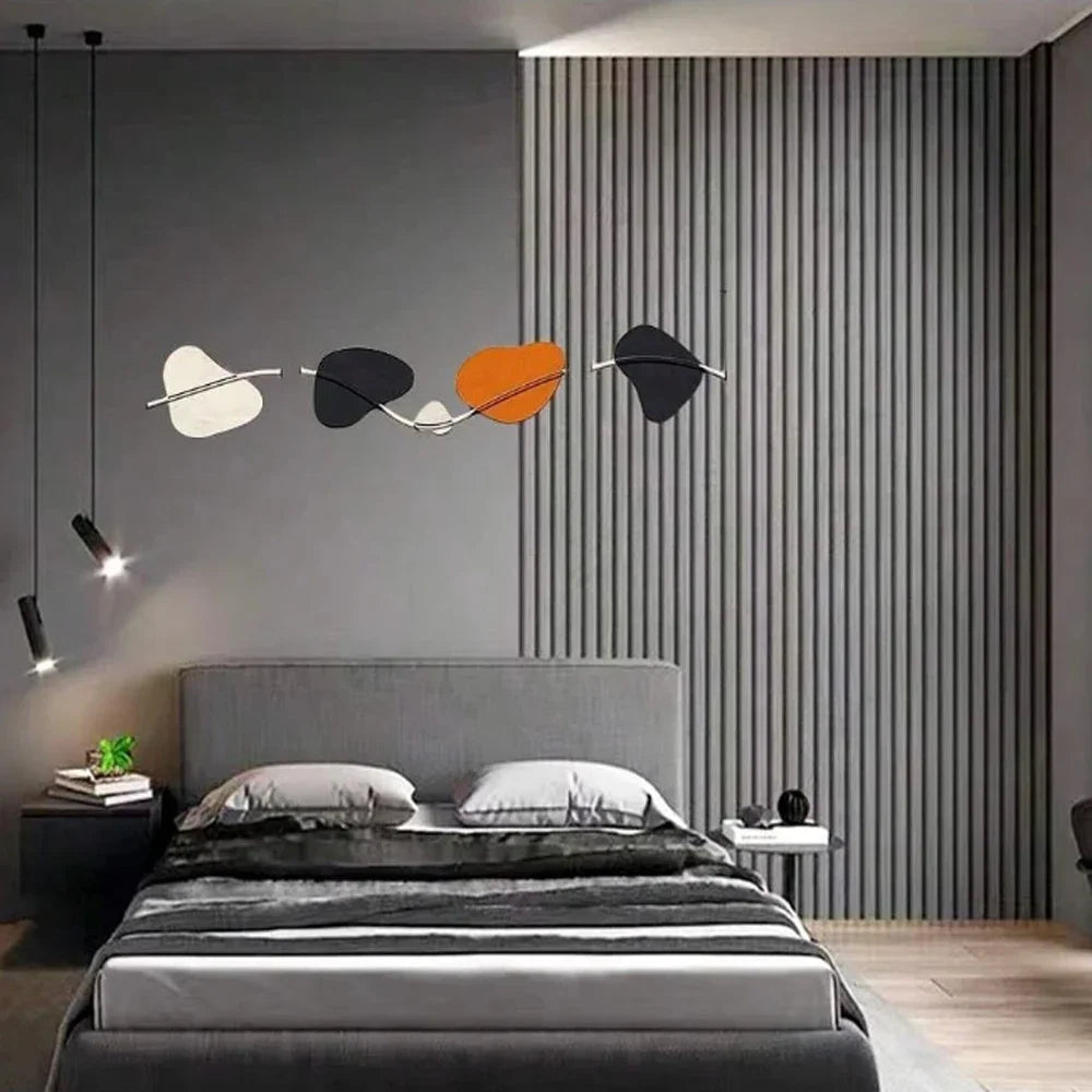 A modern bedroom featuring a bed with gray linens, accented by a wall with vertical wood grain wallpaper and decorative light