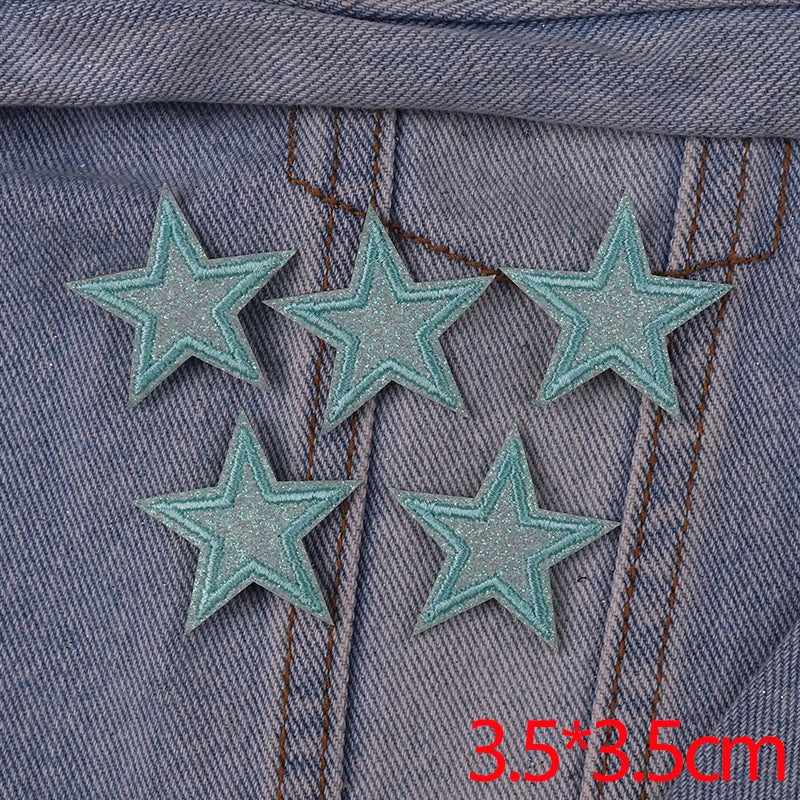 Set of five glitter heart and star iron-on embroidered patches sewn onto a denim fabric