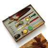 A vintage calligraphy fountain pen set with a wax seal stamp kit displayed on a wooden tray.