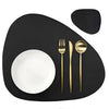 A black placemat features a white bowl and a gold fork on a dark surface.