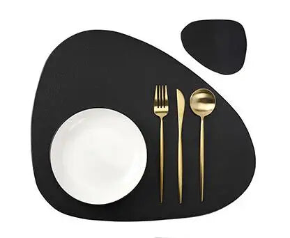 A black placemat features a white bowl and a gold fork on a dark surface.
