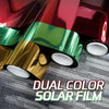 Rolls of dual color solar film showing red and green tints on a gray surface.