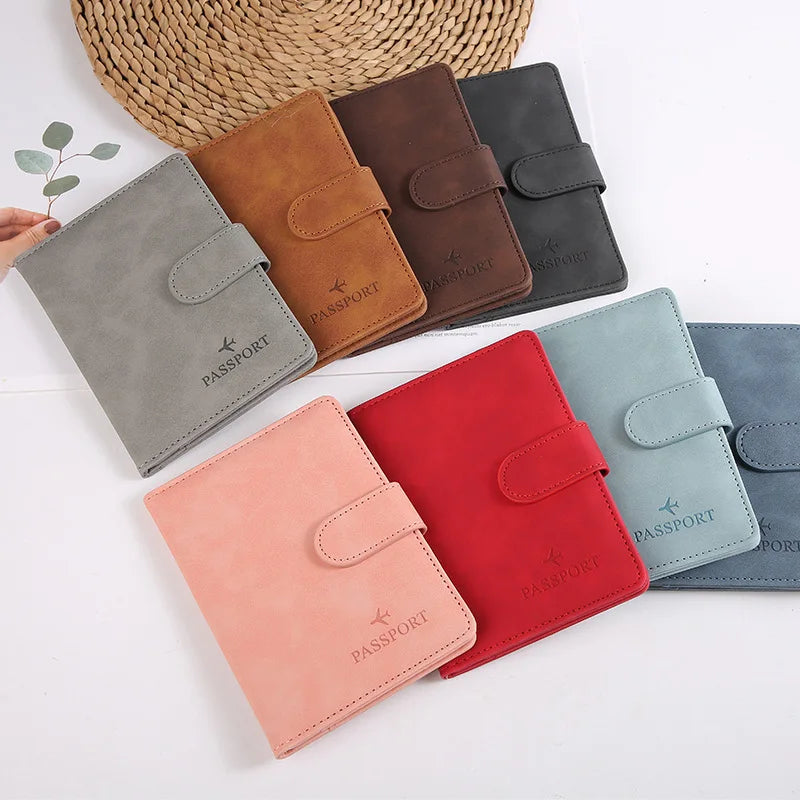 Collection de porte-passeport en cuir dans diverses nuances : brun, gris, noir et rouge, présentés sur fond blanc
