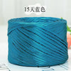 A spool of metallic teal flat ribbon yarn for crochet and knitting
