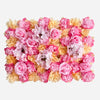 A dense wall panel of pink and peach silk rose flowers for weddings and events.