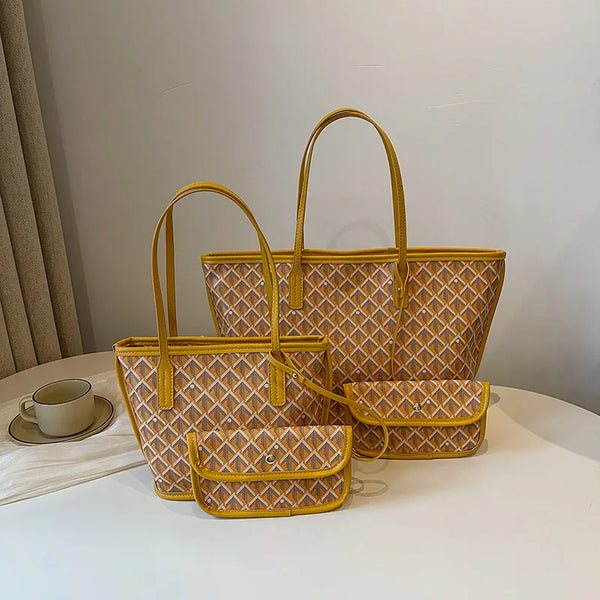 A stack of three mustard yellow patterned tote bags with leather handles resting on a white surface.