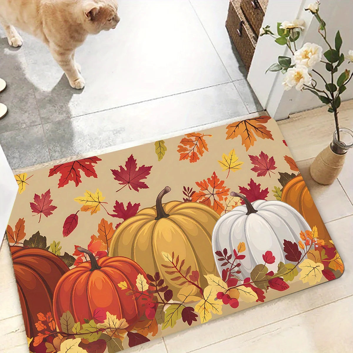 A decorative area rug featuring autumn foliage and pumpkins in orange, yellow, and white tones.