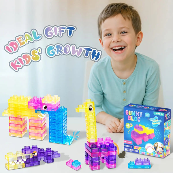 A young boy smiles while holding various colorful plastic building blocks including yellow, pink, and blue pieces.