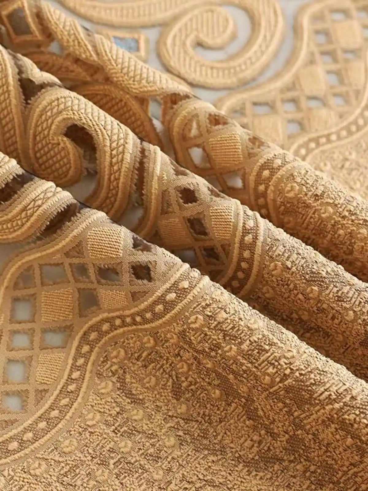 Nahaufnahme von beigen, hohlen perforierten Vorhängen mit filigraner Spitze und Zierranddetails.