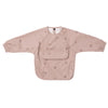 A light pink waterproof long-sleeve smock for toddlers with a chest pocket and a collar.